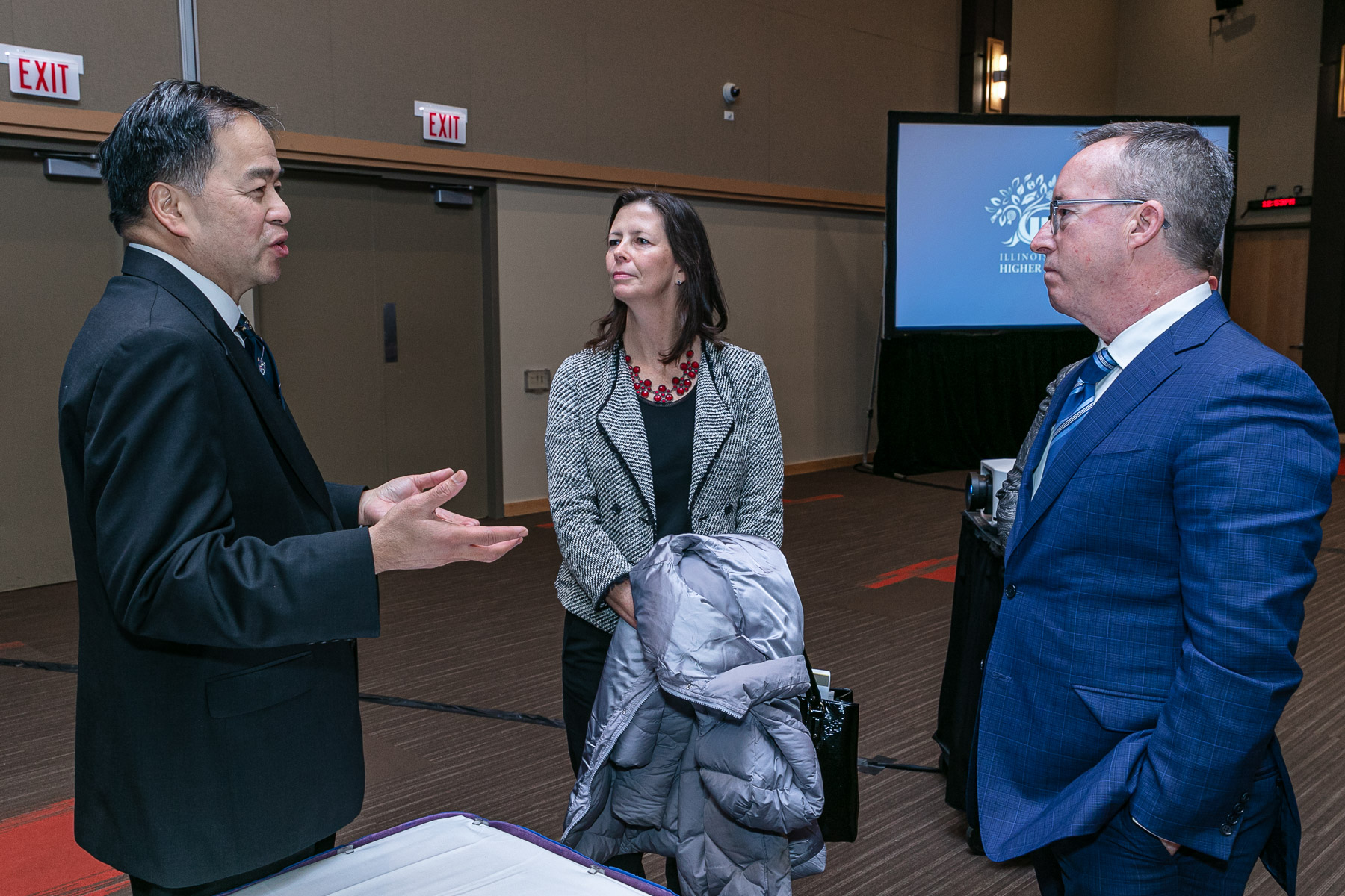 Left to right, A. Gabriel Esteban, Ph.D., president of DePaul; Illinois Rep. Kelly Burke (D); and John Atkinson, chair of Illinois Board of Higher Education; chat before the meeting begins. (DePaul University/Randall Spriggs)
